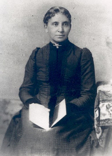 Photograph of Charlotte Forten Grimké holding a book.