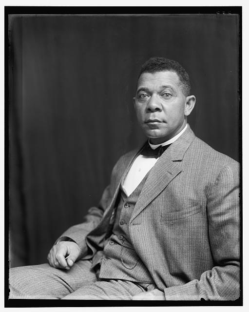 Booker T. Washington, seated, wearing three-piece suit and bow tie